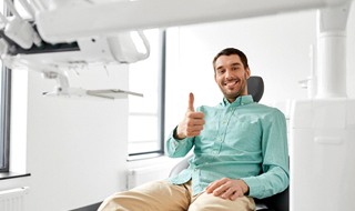 Man with thumb up in dental chair