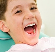 Child grinning in dental chair