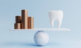 Coins balanced against tooth on scale