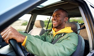 Man smiles while driving
