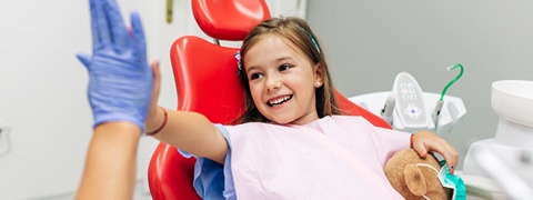 little girl giving high-five after receiving children’s dentistry in Burlington