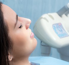 Woman relaxing with eyes closed in dental chair