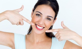 woman pointing to her bright smile