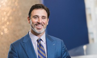 man in dark blue suit smiling