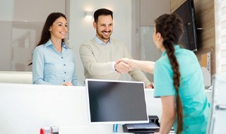 dental team member shaking hands with patient 