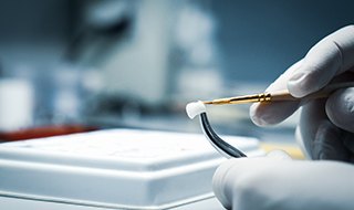 A lab worker making dental crowns