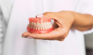 dentist holding dentures