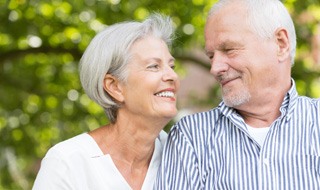 older couple smiling while looking at each other