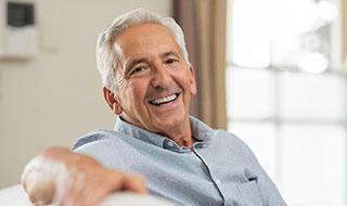 man smiling after getting dental implants in Burlington