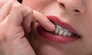 closeup of woman biting her nails