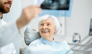 woman visiting dentist after getting dental implants Burlington 