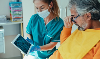 Dentist and patient reviewing dental X-ray