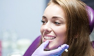 A young female is examined by a dentist to determine if she’s a qualified candidate for dental implants in Burlington