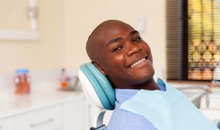 A man smiling at his dental appointment.