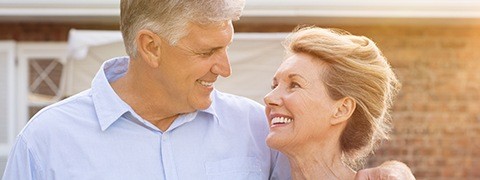 Older man and woman smiling outdoors