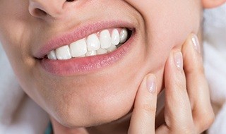 Closeup of patient holding jaw in pain