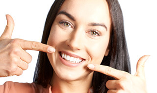 smiling woman pointing to her teeth