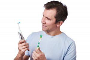 Man choosing between toothbrush options.