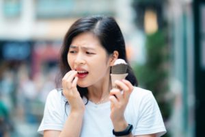 Woman with ice cream and sensitive teeth should see dentist