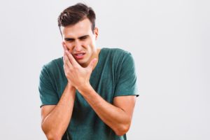 man with mouth pain due to knocked-out tooth
