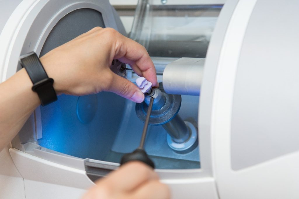 Dentist crafting a CEREC crown using a CEREC machine.